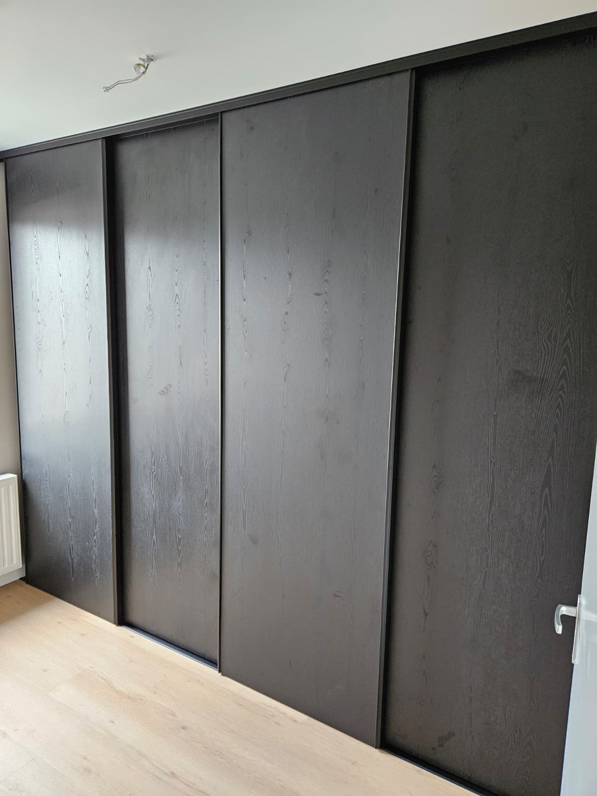 Maatwerk kledingkast met schuifdeuren in donker hout