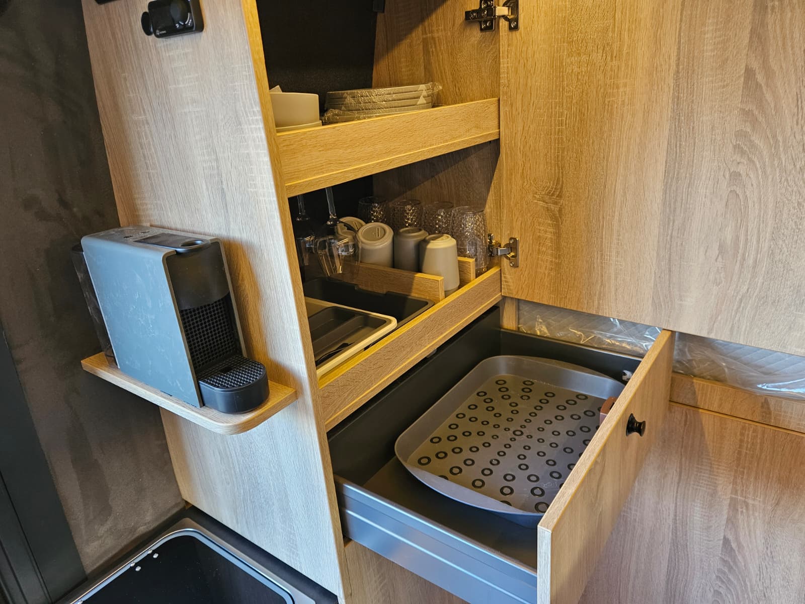 Kitchen cabinet with coffee maker and crockery